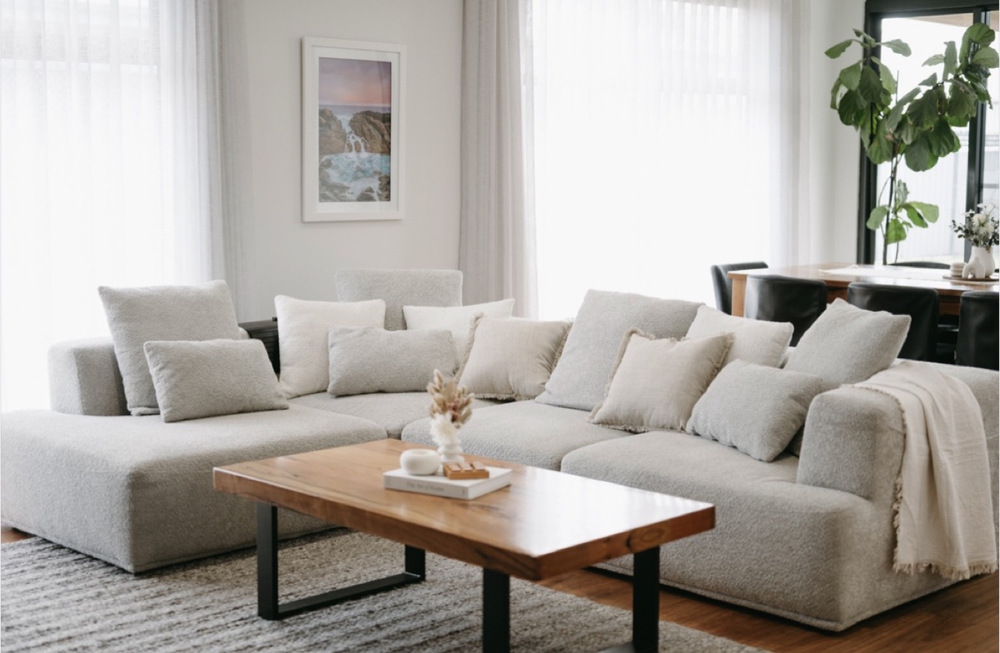 A bright, textural living room with a boucle modular sofa and timber coffee table.